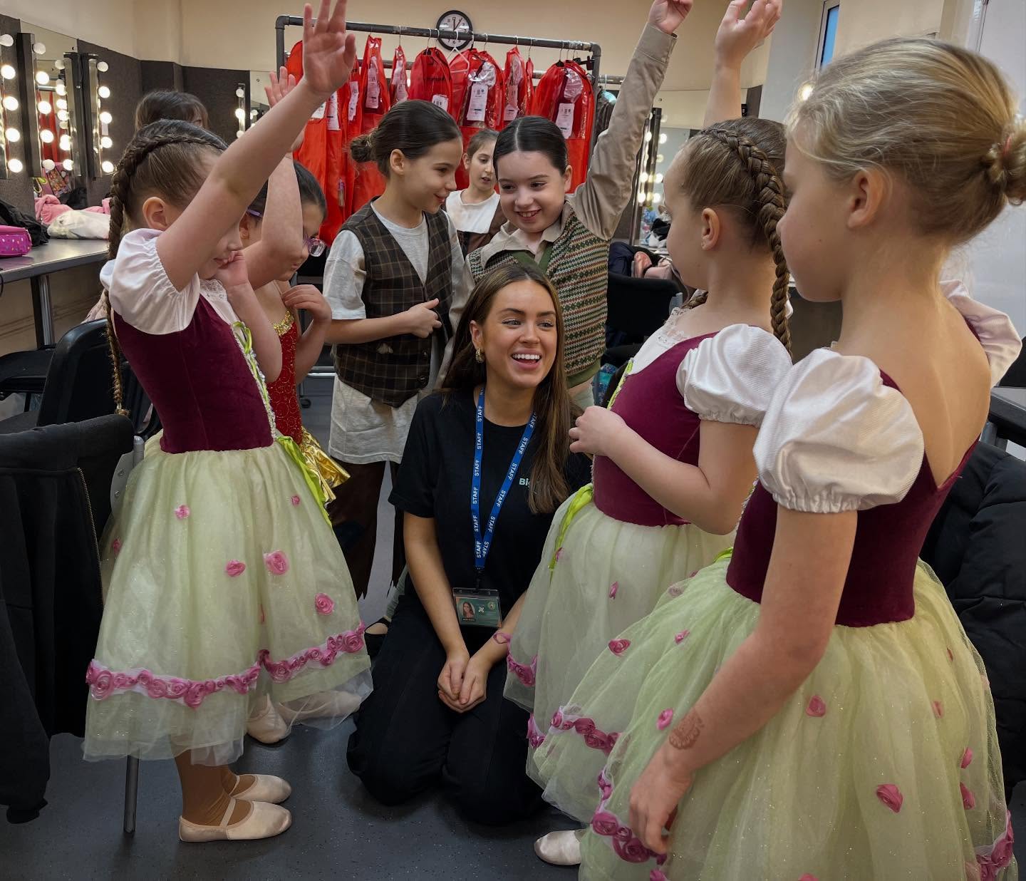 Big Time staff member with young ballet performers backstage