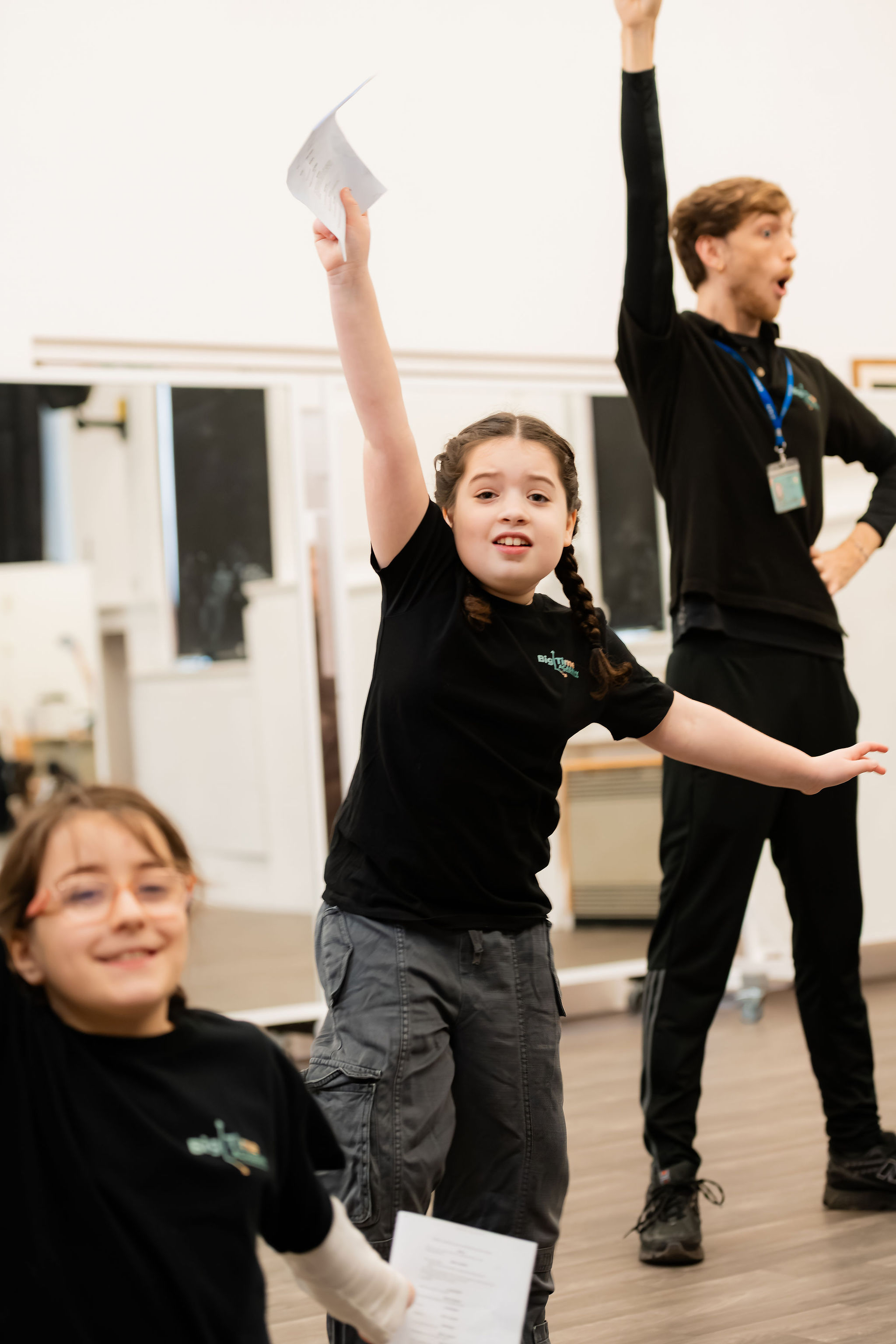 Big Time student with her arm stretched up in a rehearsal